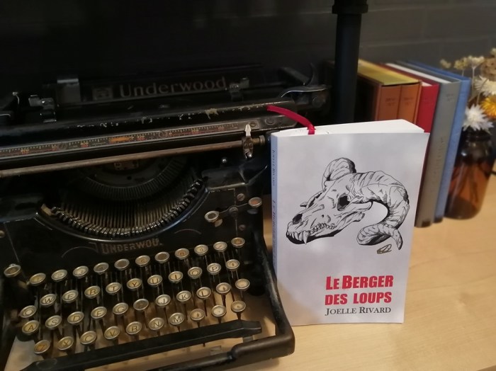 Roman le Berger des loups de Joelle Rivard repose à côté d'une vieille machine à écrire Underwood noire. Sur la couverture du roman, on aperçoit un crâne de loup avec des cornes de bélier.