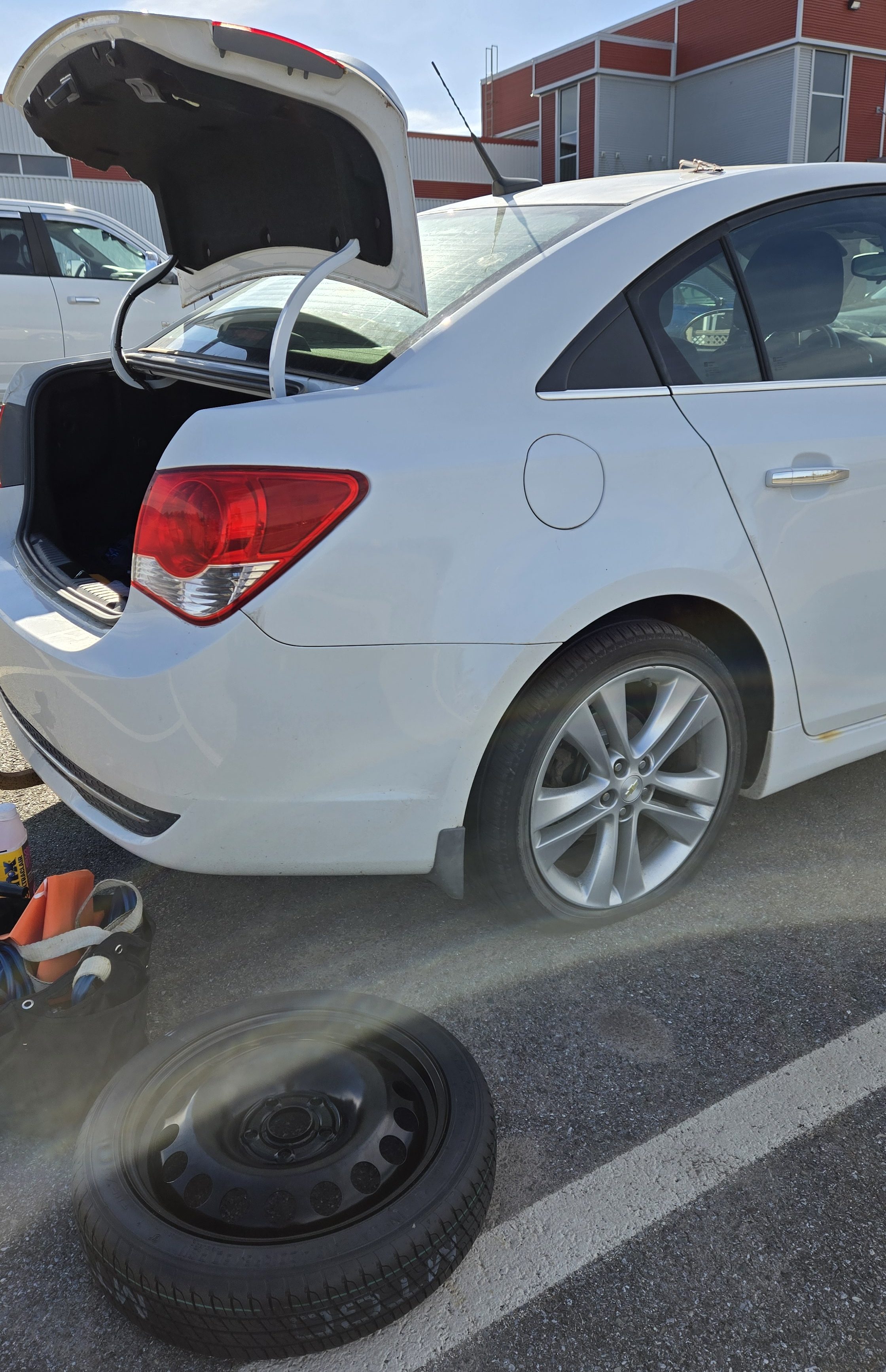 Voiture avec une crevaison et un pneu de rechange à côté
