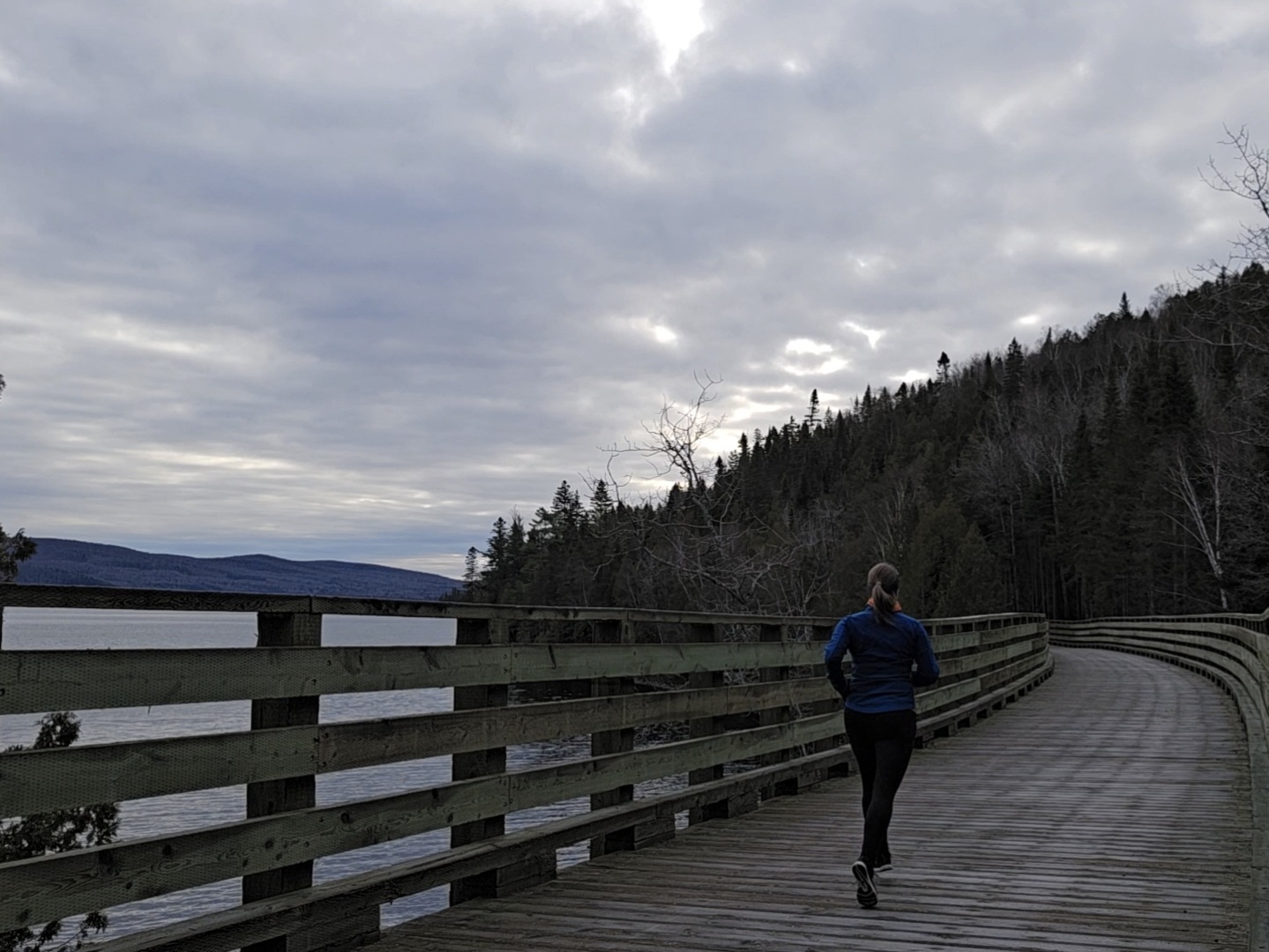 Coureuse sur un trestle en bois avec la vue sur le lac Témiscouata